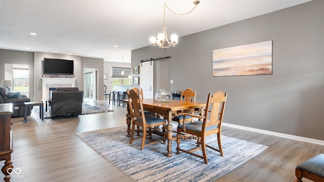 4659 W Otway Ln, New Palestine, IN 46163 - dining space featuring wood finished floors, a barn door, a fireplace, recessed lighting, and a chandelier