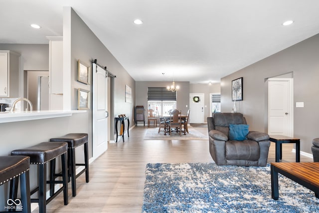 4659 W Otway Ln, New Palestine, IN 46163 - living room featuring a barn door, light wood-type flooring, a chandelier, baseboards, and recessed lighting