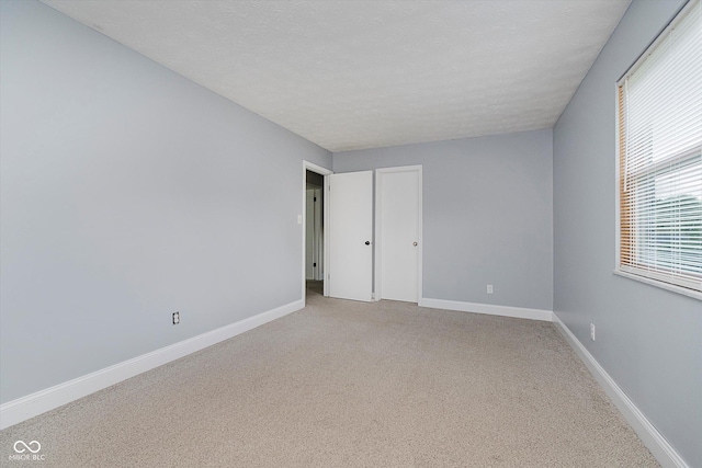5236 Honey Comb Ln, Indianapolis, IN 46221 - unfurnished bedroom with carpet flooring, baseboards, and a textured ceiling