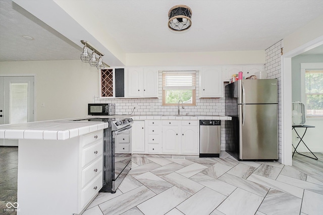 5236 Honey Comb Ln, Indianapolis, IN 46221 - kitchen featuring stainless steel appliances, tile counters, healthy amount of natural light, and tasteful backsplash