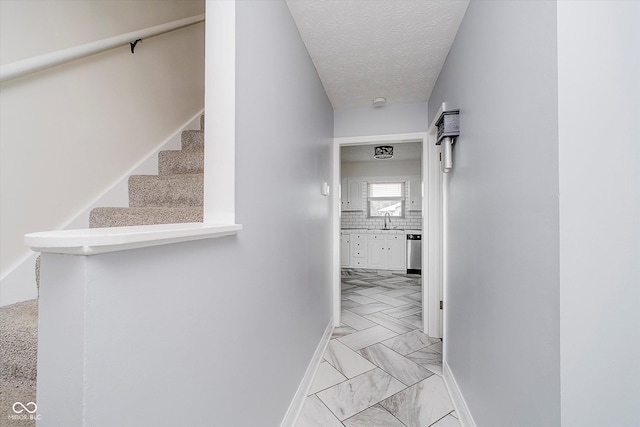 5236 Honey Comb Ln, Indianapolis, IN 46221 - hallway featuring stairway, baseboards, a sink, and a textured ceiling