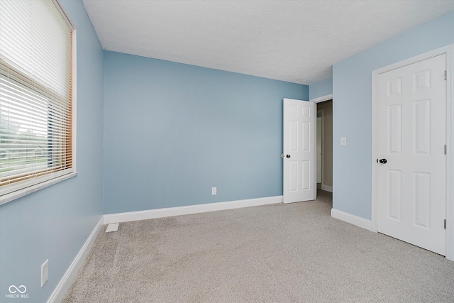 5236 Honey Comb Ln, Indianapolis, IN 46221 - unfurnished bedroom with carpet, baseboards, and a textured ceiling