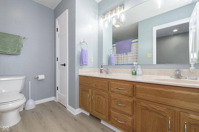 7430 Franklin Parke Woods, Indianapolis, IN 46259 - bathroom with double vanity, wood finished floors, toilet, and baseboards