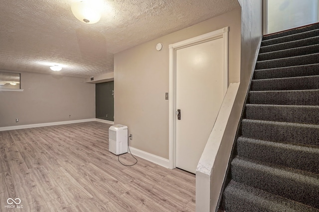 858 Cedar Wood, Carmel, IN 46032 - finished basement featuring a textured ceiling, light wood-style floors, stairs, and baseboards