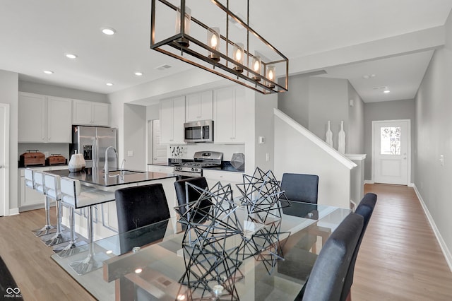 6683 Halsey St, Zionsville, IN 46077 - dining space with light wood finished floors, stairway, baseboards, and recessed lighting