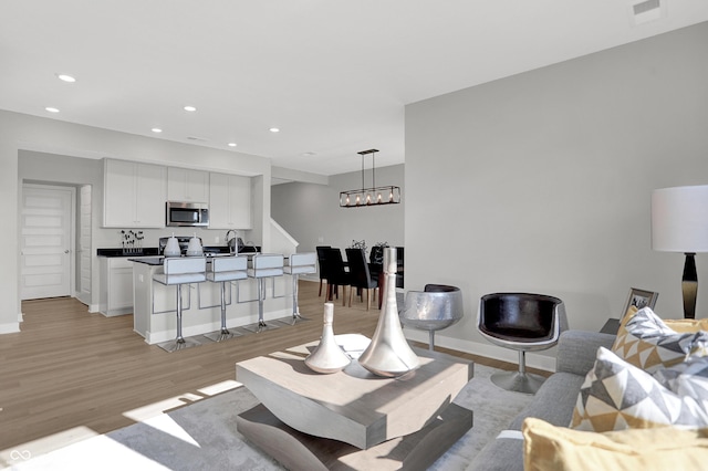 6683 Halsey St, Zionsville, IN 46077 - living area with light wood-style floors, recessed lighting, baseboards, and a chandelier
