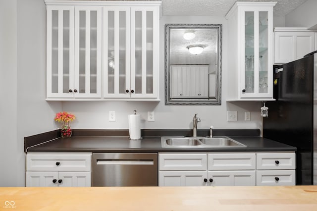 6026 Pennyworth Cir, Indianapolis, IN 46203 - kitchen featuring stainless steel dishwasher, a sink, freestanding refrigerator, white cabinets, and glass insert cabinets