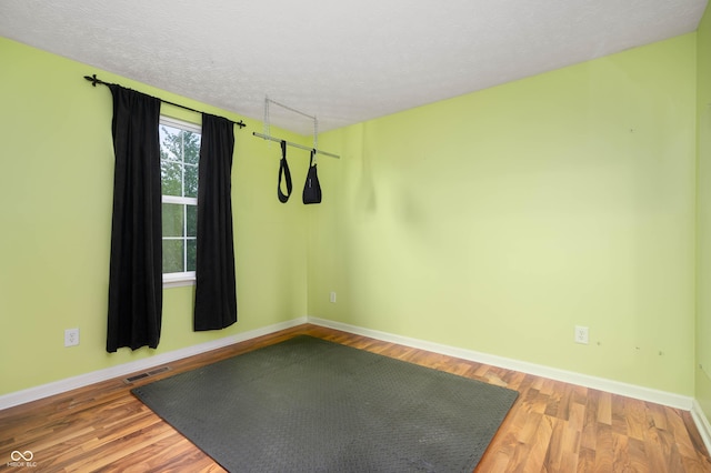 6026 Pennyworth Cir, Indianapolis, IN 46203 - unfurnished room with a textured ceiling, wood finished floors, and baseboards