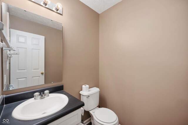 6026 Pennyworth Cir, Indianapolis, IN 46203 - half bath featuring toilet, vanity, and a textured ceiling