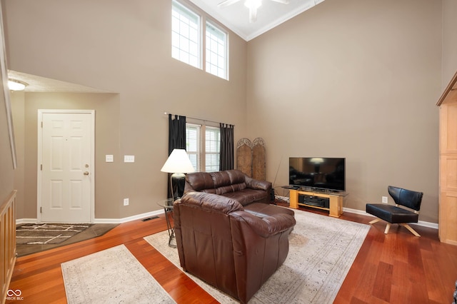 6026 Pennyworth Cir, Indianapolis, IN 46203 - living area with wood finished floors, healthy amount of natural light, a towering ceiling, baseboards, and ornamental molding