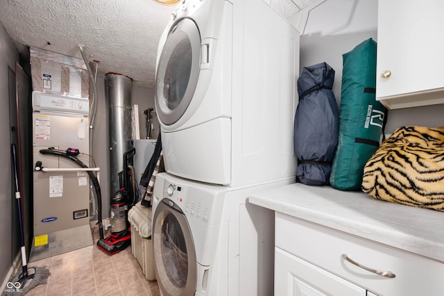 6026 Pennyworth Cir, Indianapolis, IN 46203 - laundry room with stacked washer and clothes dryer, cabinet space, and a textured ceiling