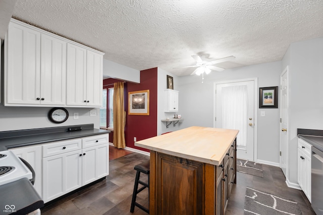 6026 Pennyworth Cir, Indianapolis, IN 46203 - kitchen with white cabinetry, a kitchen breakfast bar, a ceiling fan, a kitchen island, and range with electric stovetop