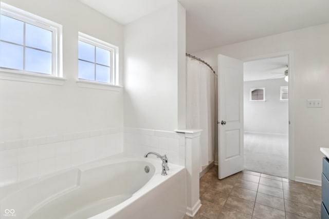 951 Parker Ln, Westfield, IN 46074 - bathroom featuring a garden tub, ceiling fan, vanity, tile patterned flooring, and baseboards