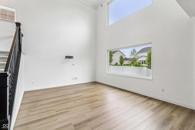 951 Parker Ln, Westfield, IN 46074 - spare room with stairway, light wood-style flooring, baseboards, and a high ceiling