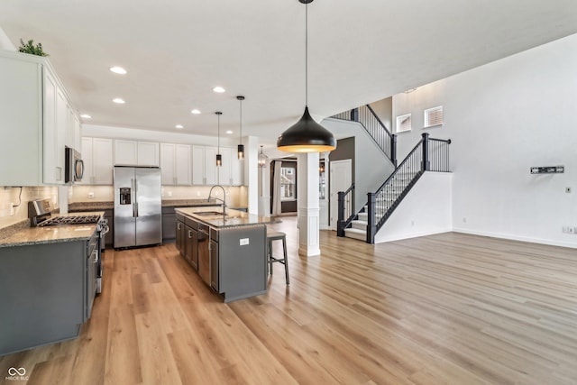 951 Parker Ln, Westfield, IN 46074 - kitchen featuring appliances with stainless steel finishes, light wood-style floors, recessed lighting, a breakfast bar, and a center island with sink