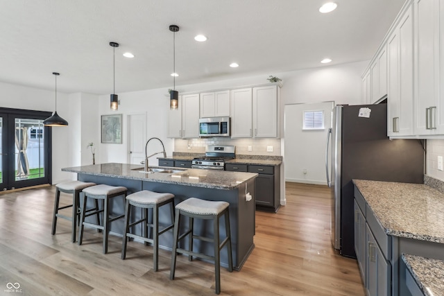 951 Parker Ln, Westfield, IN 46074 - kitchen with stainless steel appliances, a sink, decorative backsplash, a kitchen bar, and recessed lighting