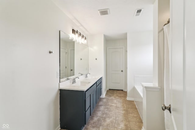 951 Parker Ln, Westfield, IN 46074 - bathroom with a garden tub, double vanity, baseboards, and tile patterned flooring