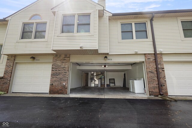 9572 Maple Way, Indianapolis, IN 46268 - view of front of property with driveway, washer / dryer, brick siding, and a garage