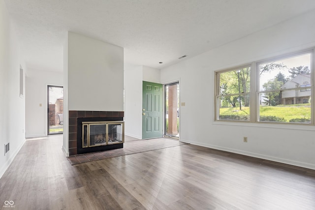 9572 Maple Way, Indianapolis, IN 46268 - unfurnished living room with wood finished floors, a tiled fireplace, and baseboards