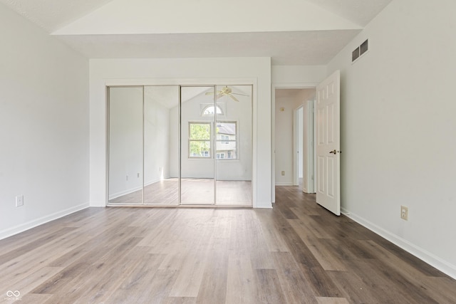 9572 Maple Way, Indianapolis, IN 46268 - unfurnished bedroom featuring lofted ceiling, wood finished floors, baseboards, and a closet