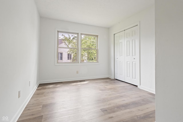 9572 Maple Way, Indianapolis, IN 46268 - unfurnished bedroom with wood finished floors, baseboards, and a closet
