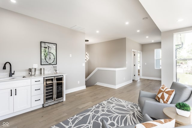 43 N Walcott St, Indianapolis, IN 46201 - living area featuring beverage cooler, wet bar, light wood finished floors, recessed lighting, and baseboards