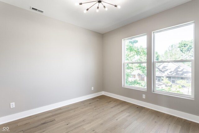 43 N Walcott St, Indianapolis, IN 46201 - empty room with a chandelier, baseboards, and light wood-style floors