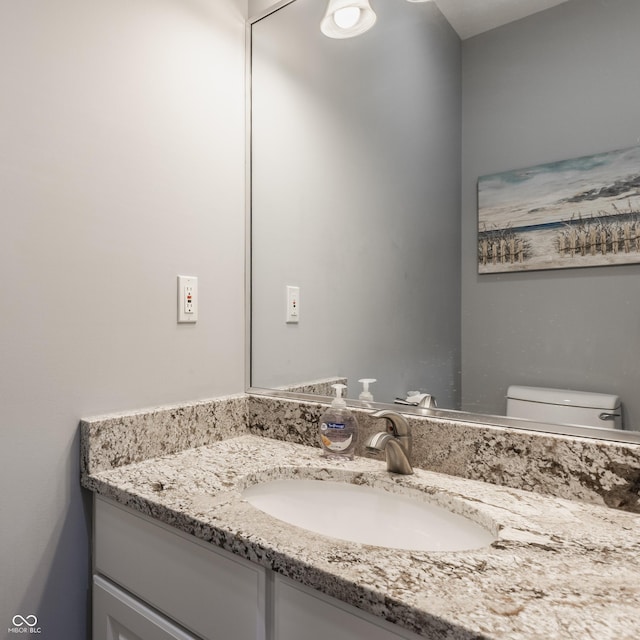 half bath featuring toilet and vanity
