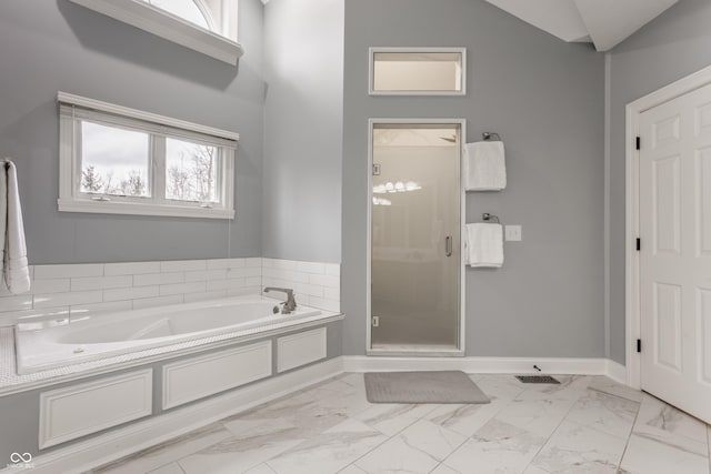 bathroom with a garden tub, a stall shower, marble look tile flooring, baseboards, and lofted ceiling
