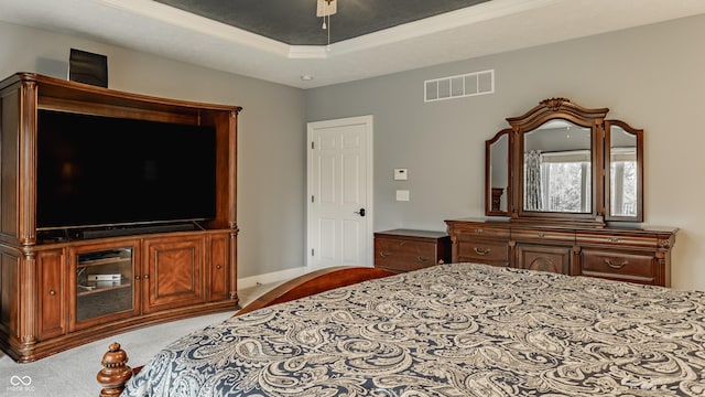 bedroom with carpet flooring, a raised ceiling, and baseboards