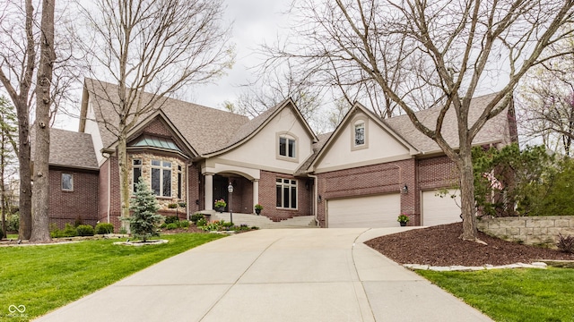 view of front of house featuring driveway, brick siding, stucco siding, a front yard, and a garage