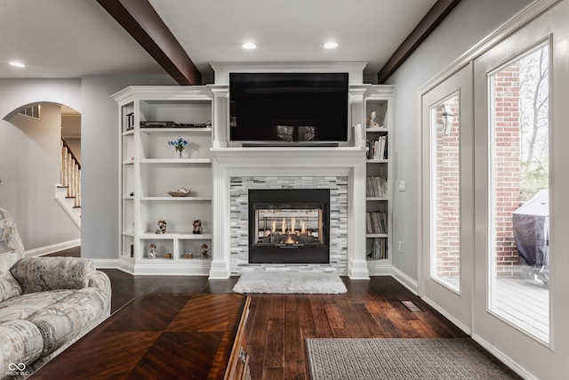 living area with dark wood-style floors, a multi sided fireplace, baseboards, stairs, and recessed lighting
