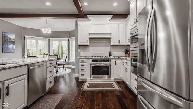 kitchen with appliances with stainless steel finishes, beam ceiling, dark wood-style floors, backsplash, and white cabinetry