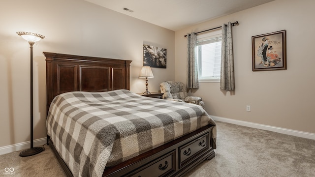 bedroom with light colored carpet and baseboards