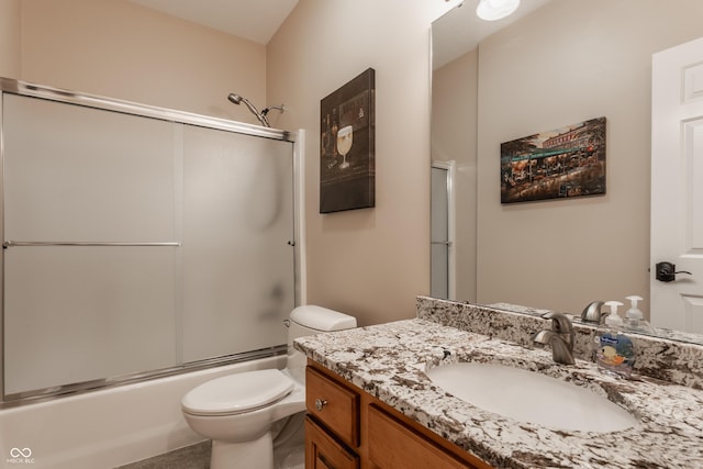 bathroom featuring toilet, vanity, and enclosed tub / shower combo