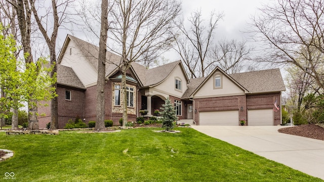view of front of property with brick siding, concrete driveway, a front yard, an attached garage, and stucco siding