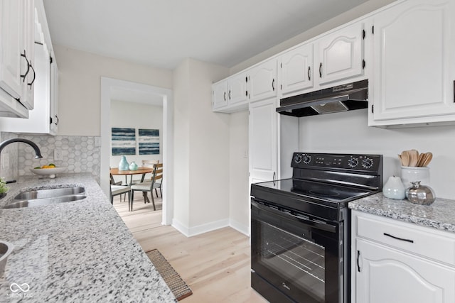 1108 N Ritter Ave, Indianapolis, IN 46219 - kitchen featuring black / electric stove, under cabinet range hood, a sink, white cabinetry, and light wood-type flooring