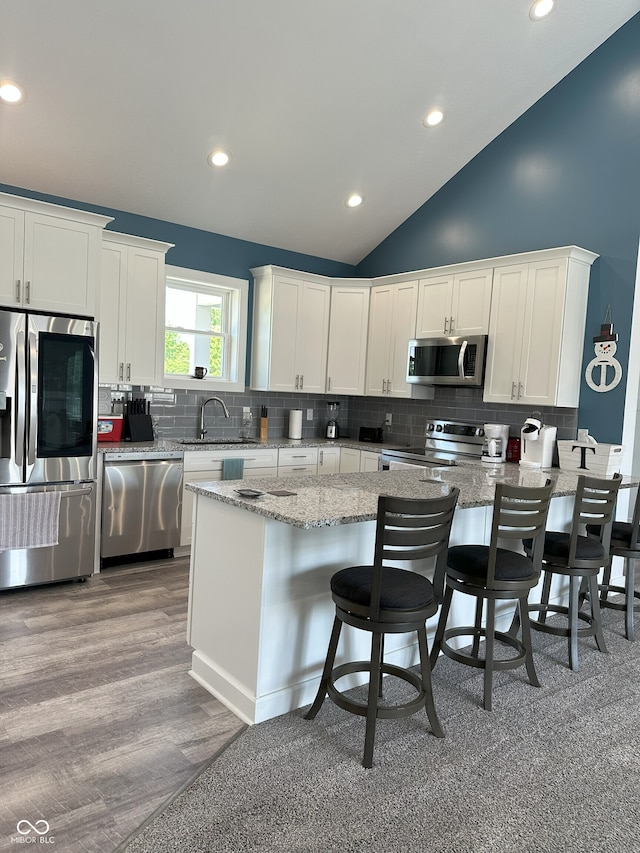 951 N Maiellen Dr, Greenfield, IN 46140 - kitchen with appliances with stainless steel finishes, a sink, backsplash, lofted ceiling, and light stone countertops