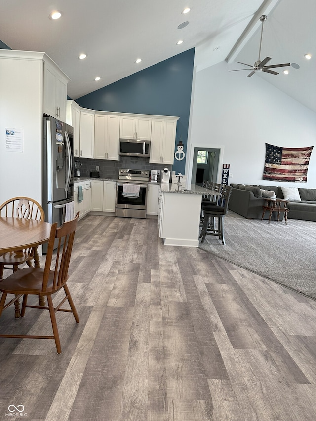 951 N Maiellen Dr, Greenfield, IN 46140 - kitchen with appliances with stainless steel finishes, open floor plan, high vaulted ceiling, wood finished floors, and a peninsula