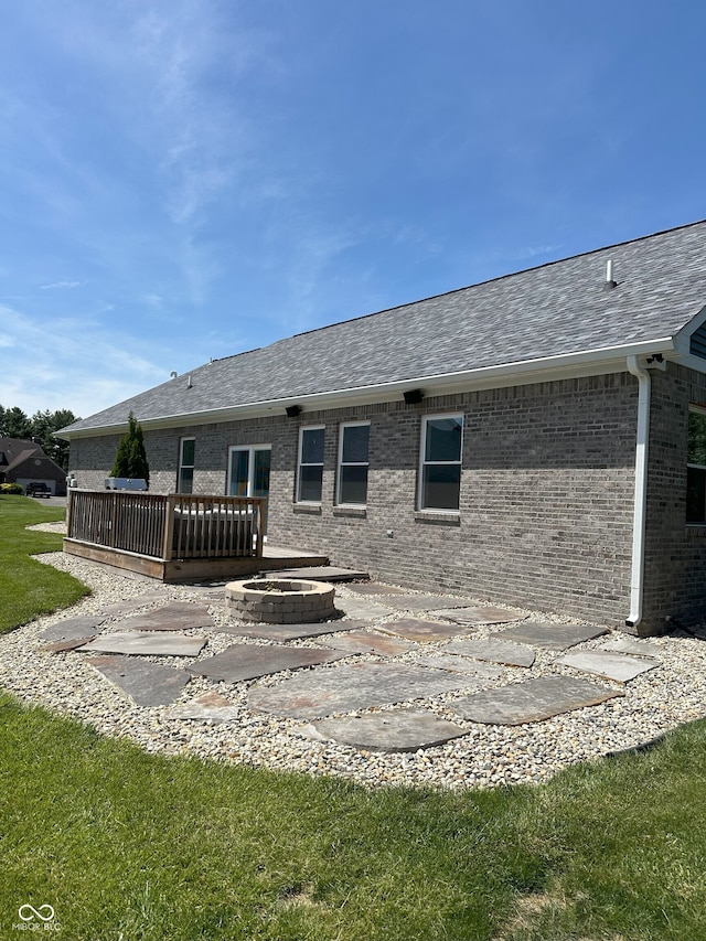 951 N Maiellen Dr, Greenfield, IN 46140 - rear view of property with a patio area, brick siding, a deck, roof with shingles, and an outdoor fire pit