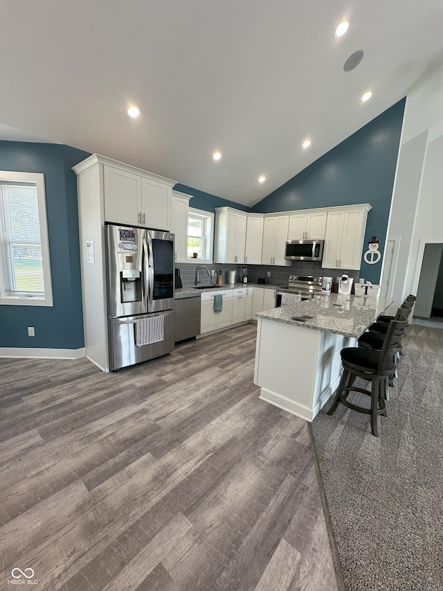 951 N Maiellen Dr, Greenfield, IN 46140 - kitchen featuring appliances with stainless steel finishes, a peninsula, decorative backsplash, white cabinets, and a sink