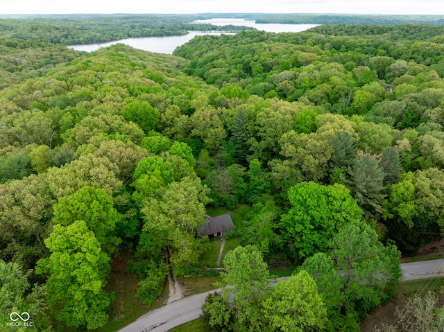 drone / aerial view of a nearby body of water and a forest