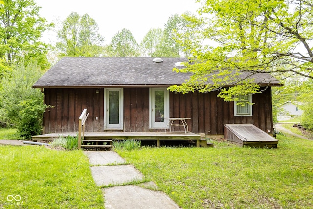 view of front of house with a shingled roof and a front lawn