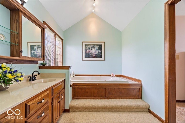 12082 Old Stone Dr, Indianapolis, IN 46236 - bathroom featuring vanity, a garden tub, lofted ceiling, rail lighting, and baseboards