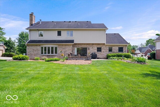 12082 Old Stone Dr, Indianapolis, IN 46236 - back of house featuring a chimney, a yard, and brick siding