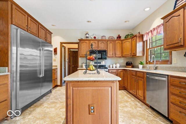 12082 Old Stone Dr, Indianapolis, IN 46236 - kitchen featuring appliances with stainless steel finishes, a sink, a kitchen island, backsplash, and recessed lighting