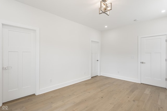 39 N Walcott St, Indianapolis, IN 46201 - empty room featuring light wood finished floors, recessed lighting, baseboards, and a chandelier