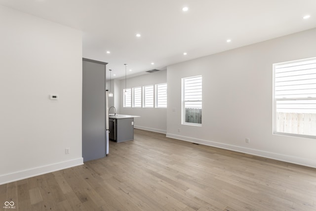 39 N Walcott St, Indianapolis, IN 46201 - unfurnished living room with baseboards, light wood finished floors, and recessed lighting