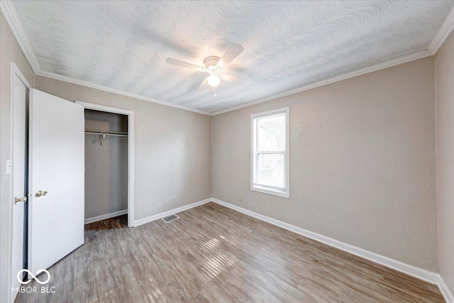 1852 N Warman Ave, Indianapolis, IN 46222 - unfurnished bedroom featuring ornamental molding, wood finished floors, a closet, ceiling fan, and a textured ceiling
