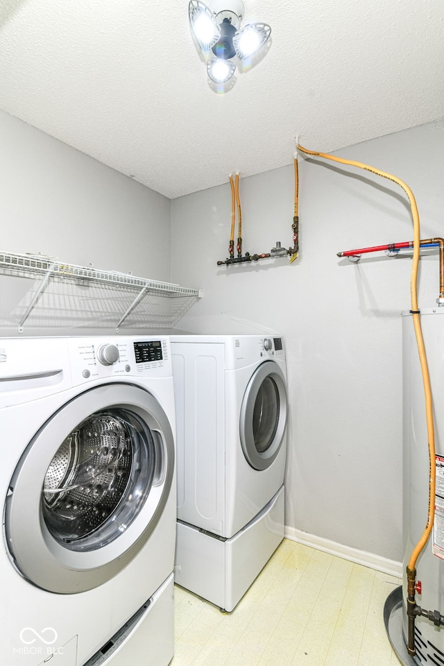 9676 W Constellation Dr, Pendleton, IN 46064 - clothes washing area featuring water heater, washer and dryer, light flooring, and baseboards